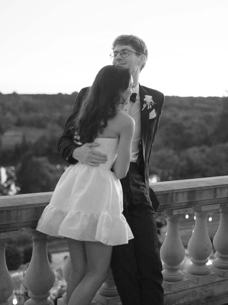 Black and white portrait of the groom holding the bride in an intimate embrace—timeless, film-inspired wedding photography by Chantel Cruz